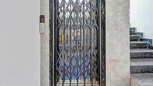 Een metalen poort met een digitaal scherm, leidend naar een trap met marmeren treden.