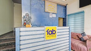 Een receptiebalie van een hotel met een bordje voor 'fab hotels' en een olifantbeeld.