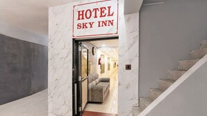 Ein Hotel Eingang mit einer Marmorwand und einem Schild, auf dem 'HOTEL SKY INN' steht.