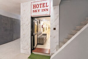 A hotel entrance with a marble wall and a sign reading 'HOTEL SKY INN'. - Fabhotel Sky Inn I (Ahmedabad)