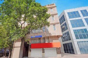 Un edifici amb un senyal de 'fab hotels' i una estructura de vidre moderna a prop.
