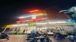Um edifício com vários sinais, incluindo 'Quartos', 'Salão de Festas' e 'Jardim'.