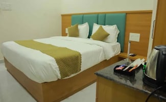 Una habitación de hotel con cama, mesita de noche y cafetera.