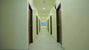 A long, narrow hallway with doors on both sides, leading to rooms. - Fabhotel Swagath Grand (Khammam)