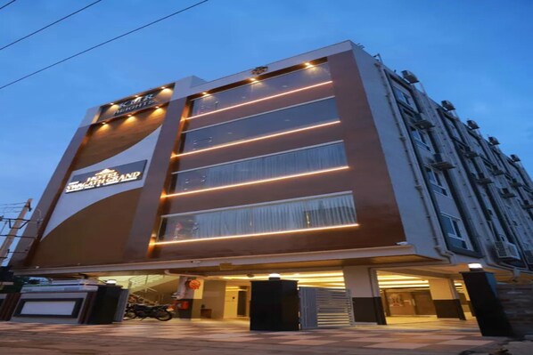 A modern hotel building with a prominent sign for 'Hotel Grand.'