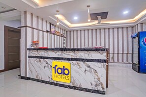A reception desk with a marble design and a 'fab hotels' sign. - FabHotel Agm (Ahmedabad)
