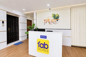A reception desk with a sign for 'fab hotels' and a peacock feather logo above it. - FabHotel Swagath Inn (Hyderabad)