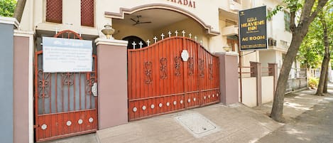 A building with a gated entrance, a sign for 'Heavens Inn AC Room,' and a sign for 'ELSHADAI.'