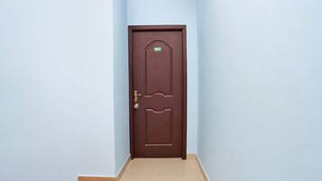 Puerta marrón cerrada con placa de identificación, picaporte y cerradura.