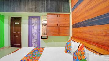 Una habitación de hotel con una cama, un cabecero de madera, una puerta con un letrero y una pared con textura.