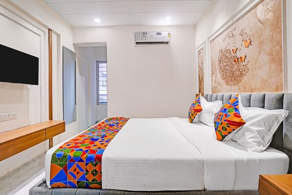 Une chambre d’hôtel équipée d’un lit, d’une télévision, d’un climatiseur et d’une fenêtre.