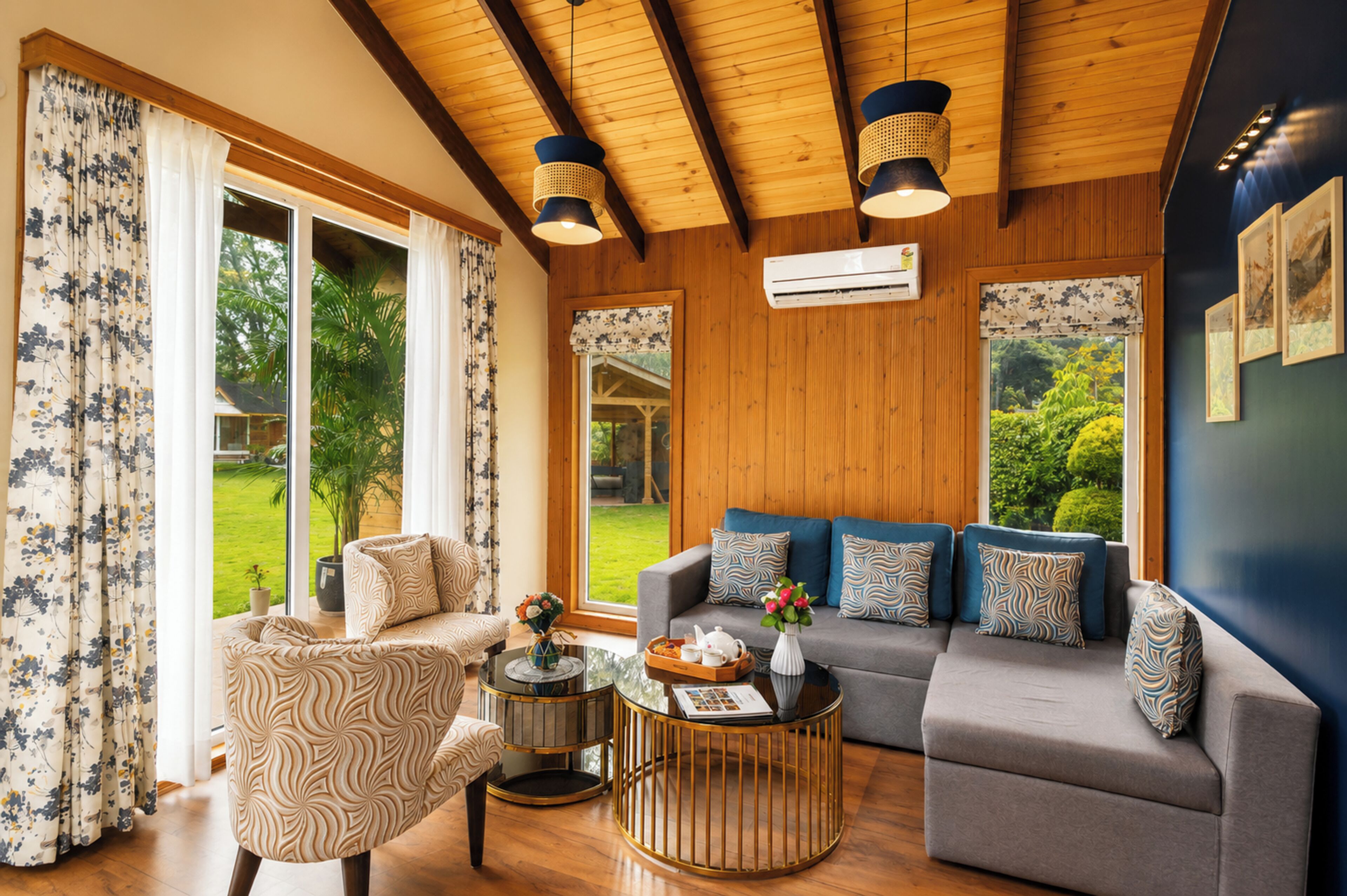 Ein Wohnzimmer mit einer Couch, Sesseln, einem Couchtisch und Blick ins Freie.