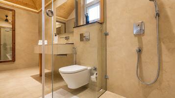 Ein modernes Badezimmer mit einer Duschkabine, einer Toilette und einem Waschbecken mit Spiegel darüber.