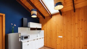 Een keuken met een modern ontwerp, voorzien van een koelkast van roestvrij staal, een magnetron, witte kasten en een backsplash met een visgraatmotief.