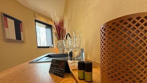 Una mesa de madera con un letrero, dos botellas pequeñas y una cesta tejida.