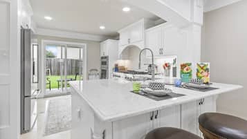 A kitchen with white cabinetry, a central island, and a dining area with a bench.