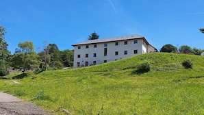 A multi-story building with a flat roof, situated on a grassy hill. - Afan Mountain Lodge (Port Talbot)
