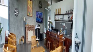 Ein geräumiger Wohnbereich mit einem Esstisch aus Holz, einem Kamin und einer Küchenzeile mit Bar.