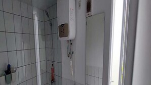 Ein Badezimmer mit Toilette, Waschbecken, Dusche und Spiegel.