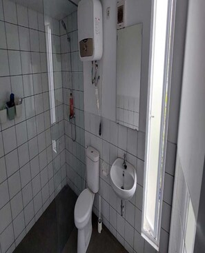 A bathroom with a toilet, sink, shower, and a mirror. - Cozzy Villa Nirwana Pangalengan (Pangalengan)