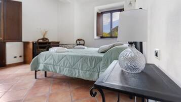 Une chambre à coucher avec un lit, une table de chevet et une fenêtre donnant sur un beau paysage.