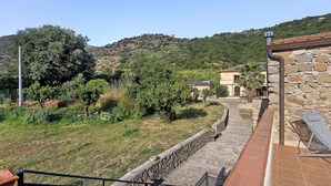 A stone building with a paved pathway leading to a bench.