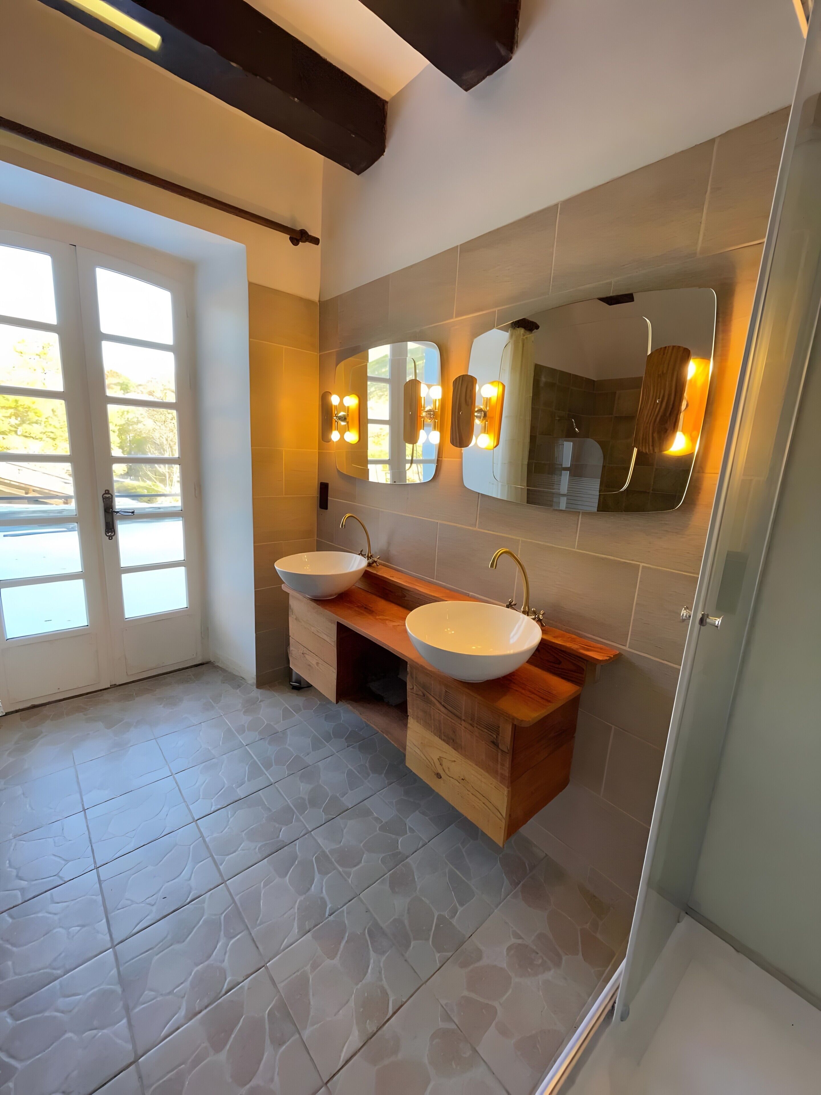 Un baño moderno con dos lavamanos, un mueble de tocador y un espejo grande con iluminación.