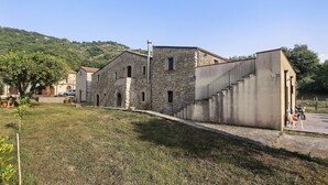 Un edificio de piedra con una escalera que lleva a una sección de techo plano.
