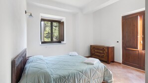 Un dormitorio con cama, cómoda, ventana y puerta.
