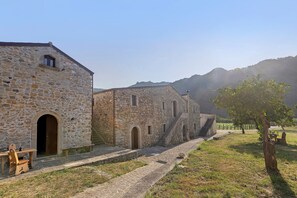 Edifici de pedra amb un arc i una escala que condueix a un segon pis.