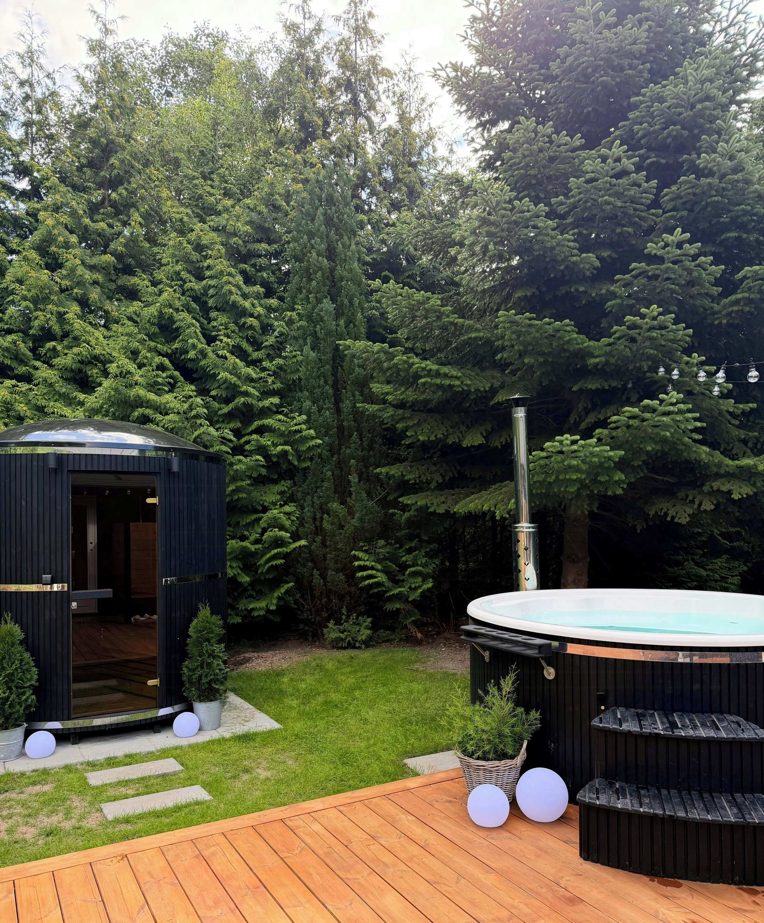 A wooden deck with a hot tub, a small shed, and a garden area with potted plants and stepping stones.