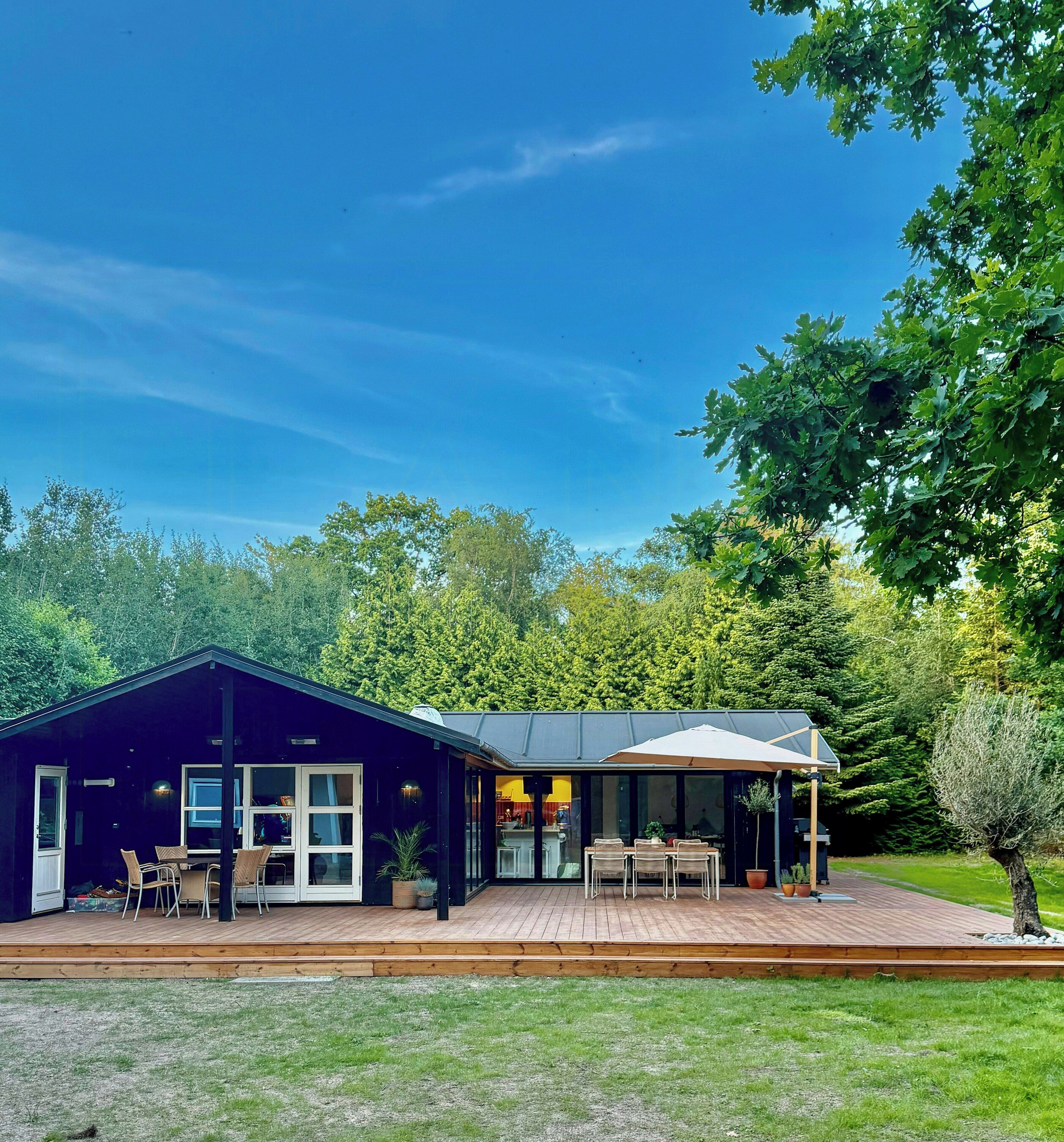 A modern house with a covered patio area, a deck, and a garden.