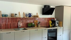 A modern kitchen with a built-in oven, a sink, and a microwave.