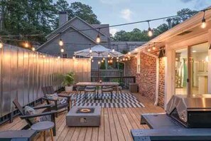 A deck with outdoor furniture, a barbecue grill, and string lights. - N. Druid Hills-MidMod Retreat - A. Blank Children's Hosp - 100+ 5 star reviews (Atlanta)