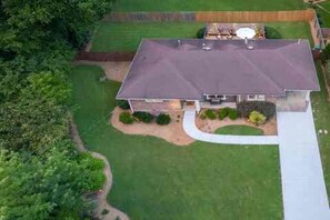 A single-story house with a flat roof, surrounded by a well-maintained lawn and a wooden fence. - N. Druid Hills-MidMod Retreat - A. Blank Children's Hosp - 100+ 5 star reviews (Atlanta)