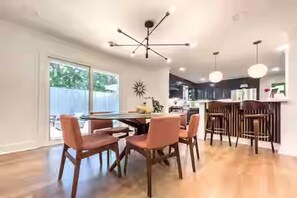 A modern dining area with a central table, chairs, and pendant lighting. - N. Druid Hills-MidMod Retreat - A. Blank Children's Hosp - 100+ 5 star reviews (Atlanta)