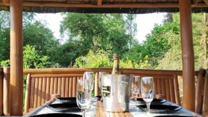 Een buiten eethoek met een tafel voor twee, een champagnefles en glazen.