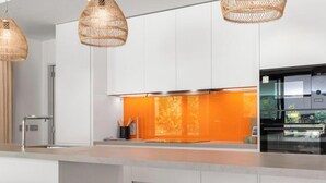 A modern kitchen with white cabinets, a built-in orange backsplash, and a stainless steel refrigerator. - Brinkmann | Modern - Plunge Pool - Terrace (Fuengirola)