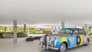A spacious indoor area with a classic car parked near a modern building with large windows. - Brinkmann | Modern - Plunge Pool - Terrace (Fuengirola)