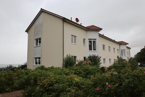 Um edifício de dois andares com telhado plano e várias janelas.