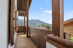 A wooden balcony with a view of mountains.