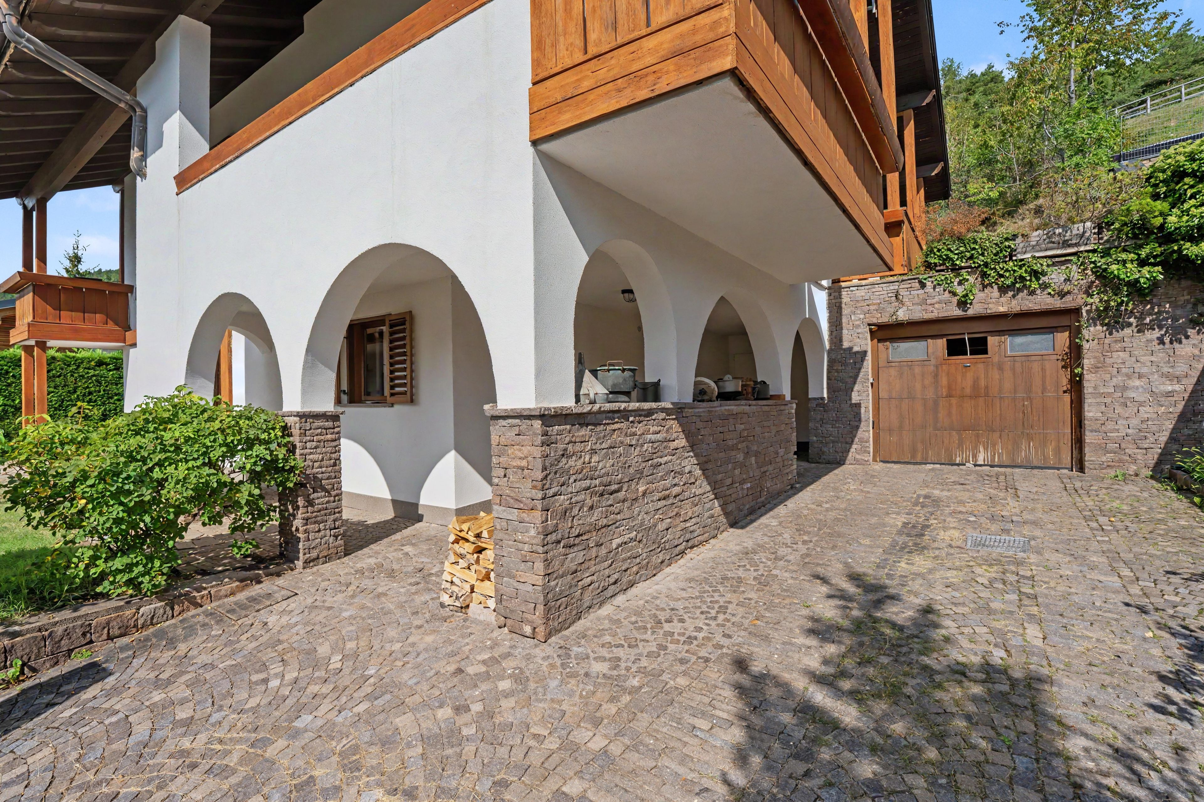A building with a stone facade, wooden beams, and a garage.