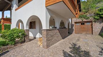 A building with a stone facade, wooden beams, and a garage.