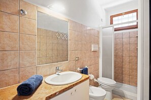 A bathroom with a sink, mirror, towel, toilet, and shower. - Casa Franca – terrace with a view of the bay, 200 meters from the sea (Golfo Aranci)