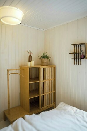 A wooden bunk bed with a headboard, a bedside table, and a hanging light fixture. - Nordic retreat with wilderness bath near Marielyst (V)