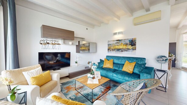 A modern living room with a sofa, coffee table, and a television. - Sirmio Dream View Suite by Bookinggardalake (Sirmione)