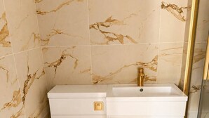 Ein Badezimmer mit Toilette, Waschbecken und Wänden mit Marmoroptik.