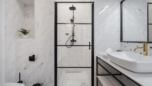 A modern bathroom with a glass-enclosed shower, a white sink, and a marble-tiled wall. - Budapest Cereja Boutique (Budapest)