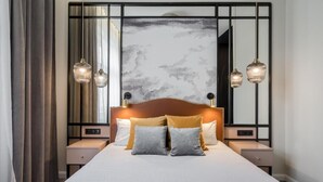 A neatly made bed with a headboard, two bedside tables, and a large mirror. - Budapest Cereja Boutique (Budapest)