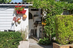 Il s’agit d’une propriété résidentielle à l’extérieur blanc, dotée d’un petit jardin et d’une clôture en bois.